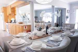 a dining room table with plates and glasses on it at LazyYzer in Yzerfontein