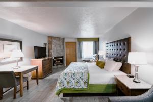 a hotel room with a large bed and a desk at Accommodations By Willow Brook Lodge in Pigeon Forge
