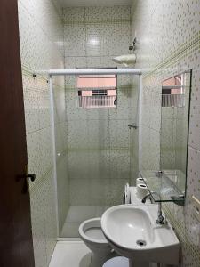 a bathroom with a shower and a sink and a toilet at Hotel Araçariguama in Araçariguama