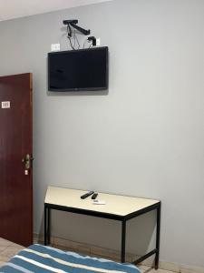 a room with a table and a tv on a wall at Hotel Araçariguama in Araçariguama +5 photos