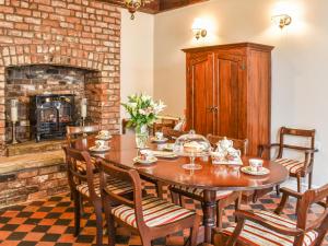 a dining room with a table and a fireplace at Heritage Lodge in Rhyl
