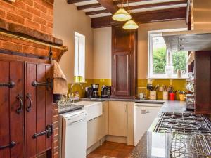 a kitchen with white appliances and a brick wall at Heritage Lodge in Rhyl +18 photos