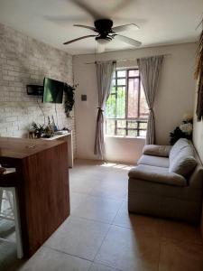 a living room with a couch and a ceiling fan at Majos Aldea Tulum in Tulum