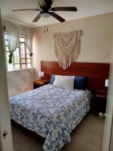 a bedroom with a bed and a ceiling fan at Majos Aldea Tulum in Tulum