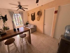 a living room with a table and a ceiling fan at Majos Aldea Tulum in Tulum