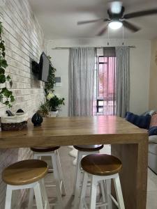 a living room with a large wooden table and stools at Majos Aldea Tulum in Tulum +9 photos