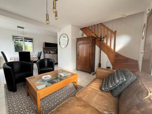 a living room with a couch and a table at Maison des Dunes in Plougoulm