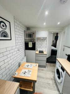 a small kitchen with a table and a washer at Yastayzzz Studio 2 Worcester House with Free Parking in Worcester