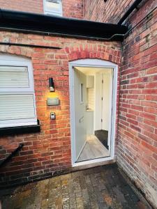 a brick house with a door and a brick wall at Yastayzzz Studio 2 Worcester House with Free Parking in Worcester