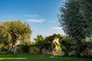 two people standing in front of a stone wall at Casal Sikelio in Cassibile