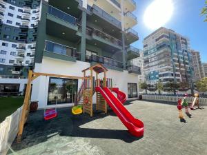 a playground with a slide in front of a building at Serenity Residence apartment in Alanya