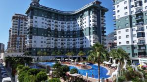 a hotel with a pool in front of two tall buildings at Serenity Residence apartment in Alanya