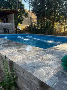a swimming pool with blue water in a yard at Domo, Cabaña, El Rulo Coinco in Rancagua