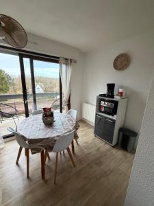 a dining room with a table with chairs and a stove at appartement à Sainte Cecile in Camiers