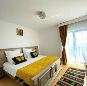 a bedroom with a bed and a large window at Agropensiunea Paradisul Verde in Jurilovca