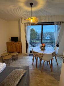 a living room with a table and a large window at appartement à Sainte Cecile in Camiers