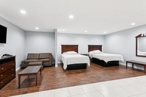 a hotel room with two beds and a couch at Laplace Motel in Laplace