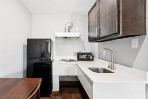 a kitchen with a sink and a black refrigerator at Laplace Motel in Laplace