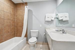 a bathroom with a toilet and a tub and a sink at Laplace Motel in Laplace