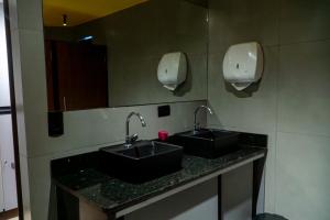 a bathroom with two sinks and two paper towels at Favela Hostel in Rio de Janeiro +20 photos