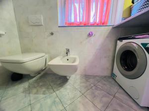 a bathroom with a toilet and a washing machine at Suite La Brezza - Luxury Sanremo in Sanremo