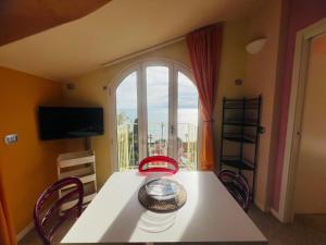 a dining room with a table and a large window at Suite La Brezza - Luxury Sanremo in Sanremo