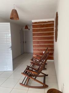 a wooden rocking chair sitting in a room at Luar Dos Milagres in São Miguel dos Milagres +1 photo