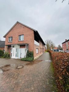 a brick house with a white garage on a street at Fewo am Disselhook in Lüdinghausen