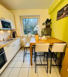 a kitchen with a wooden table and chairs and a window at Fewo am Disselhook in Lüdinghausen