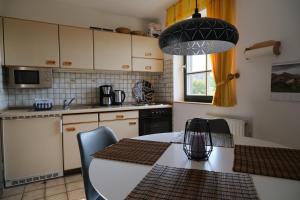 a kitchen with a white table with chairs and a kitchen at Nordseewohnung Strandloeper in Wittmund