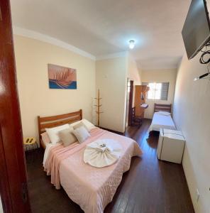 a bedroom with a bed with a flower on it at Hotel Chão Mineiro in São Thomé das Letras