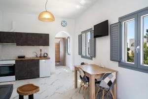 a kitchen and dining room with a wooden table at Aerial Apartments in Karterados