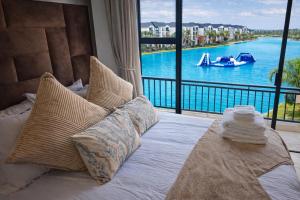 a bedroom with a bed with a view of the water at Spectacular Lagoon Facing Apartment - The Blyde in Pretoria