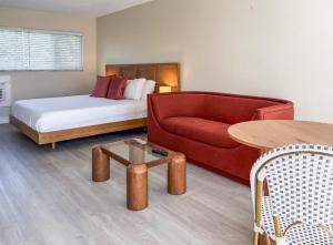 a room with a bed and a couch and a table at Ocean Lodge in Boca Raton