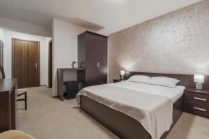 a hotel room with a large bed and a desk at Pensiunea Popasul Ursilor Medve Barlang Peștera Urșilor in Chişcău +87 photos