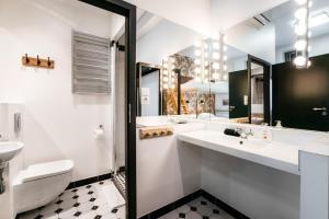 a bathroom with two sinks and a toilet and a mirror at Cocorico Bed and Breakfast OLD TOWN Szczecin Adults Only in Szczecin +27 photos