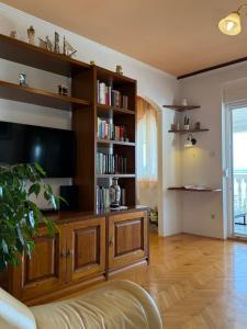a living room with a large wooden entertainment center at Apartment Ornik in Crikvenica