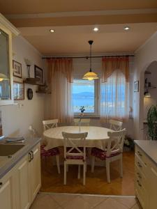 a kitchen with a table and chairs with a view of the ocean at Apartment Ornik in Crikvenica +19 photos
