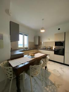 a kitchen with a wooden table and white chairs at Apartment Rino 1 Caorso in Caorso