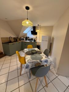 a kitchen with a table and chairs in a room at La parenthèse d'Opale in Wissant