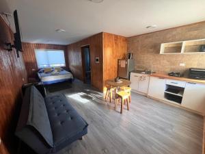 a kitchen and a living room with a couch and a table at Departamentos Confluencia in Cochrane