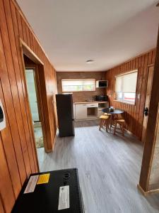 a room with a kitchen with a refrigerator and a table at Departamentos Confluencia in Cochrane