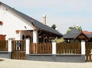 a house with a wooden fence in front of it at Ádi Vendégház - Bekecs in Bekecs