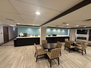 a waiting room with tables and chairs and a counter at Quality Inn & Suites Detroit Metro Airport in Romulus