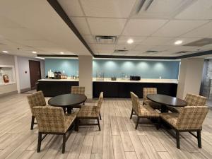 a waiting room with two tables and chairs and a counter at Quality Inn & Suites Detroit Metro Airport in Romulus