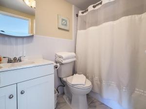 a white bathroom with a toilet and a sink at Ocean Lodge in Boca Raton +20 photos
