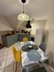a kitchen with a table and yellow chairs in a room at La parenthèse d'Opale in Wissant
