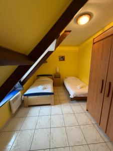 two beds in a room with yellow walls at Le secret d'Opale in Wissant