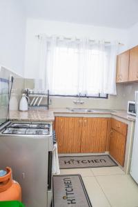 a kitchen with a stove and a sink and a window at Chesum's suites in Eldoret
