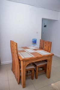 a wooden table with two chairs around it at Chesum's suites in Eldoret